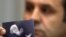 Rasim Ljajić, predsednik Nacionalnog saveta za saradnju sa Haškim tribunalom, drži fotografiju na kojoj je Radovan Karadžić