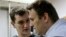 Russian opposition leader and anticorruption blogger Aleksei Navalny (front) and his brother and co-defendant Oleg attend a court hearing in Moscow in December 2014.