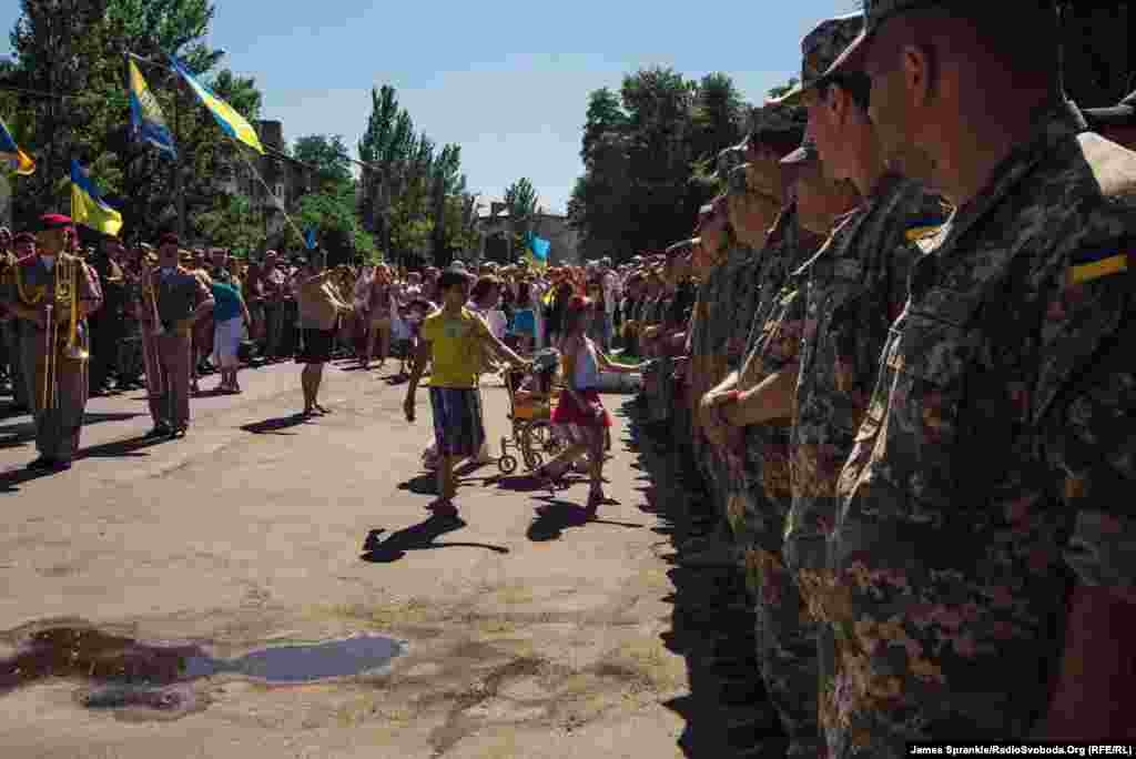 Місцеві діти дарують квіти захисникам міста з нагоди річниці визволення