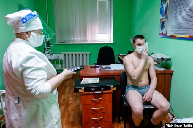Një rekrut i nënshtrohet një testi mjekësor në një qendër rekrutimi, para se të niset për shërbim ushtarak me ushtrinë ruse në Kaliningrad, Rusi, më 2021.
