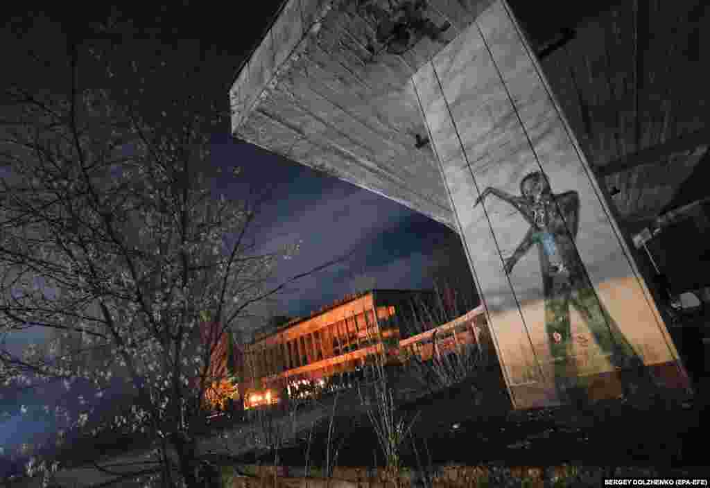 Candlelight from an overnight vigil illuminates a building in the abandoned city of Prypyat, near Chernobyl.