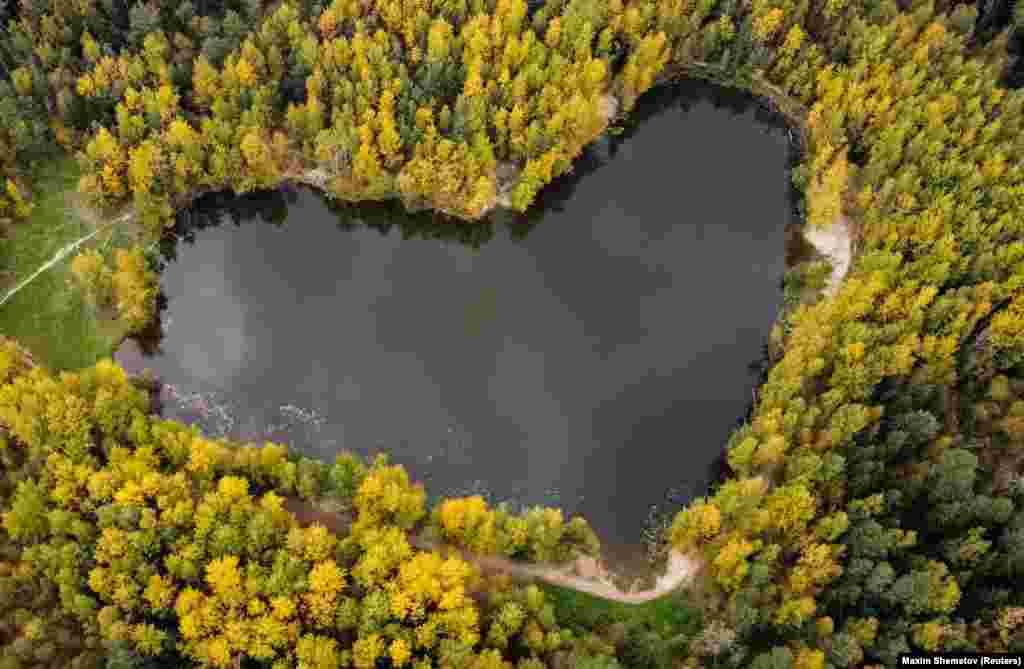 A lake in the shape of a heart is seen surrounded by autumn-colored trees near Balashikha, outside Moscow.