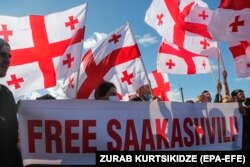 Tüntetők követelik Miheil Szaakasvili szabadon engedését a rusztavi börtön előtt 2021. október 4-én. Az exelnököt többek között hatalommal való visszaélés miatt ítélték letöltendő büntetésre, még távollétében