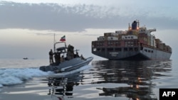 Катер иранского Корпуса стражей исламской революции (КСИР) приближается к грузовому судну в Ормузском проливе