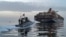 Катер иранского Корпуса стражей исламской революции (КСИР) приближается к грузовому судну в Ормузском проливе