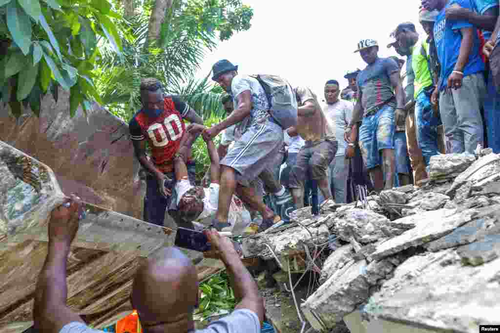 Izvlačenje tijela političara Jeana Gabriela Fortunea iz ruševina nekadašnjeg hotela u Les Cayesu (14. avgust)