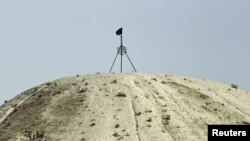 Прапор угруповання «Ісламська держава» на пагорбі в містечку Тель-Аб’яд на сирійсько-турецькому кордоні, вересень 2014 року (архівне фото)