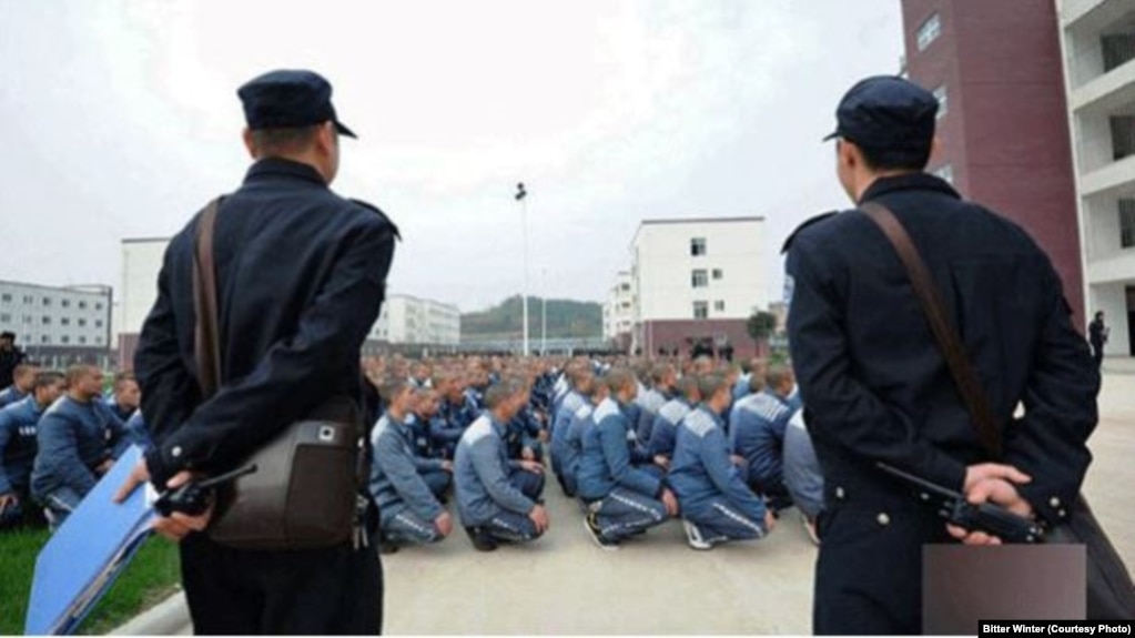 Охранники наблюдают за заключенными лагеря перевоспитания в районе Синьцзян на северо-западе Китая. Декабрь 2018 года.