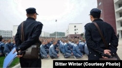 Сотрудники тюрьмы наблюдают за заключенными в лагере политического перевоспитания в Синьцзяне. 2018 год