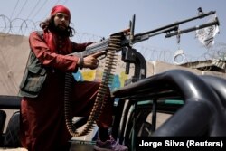 Боевик «Талибана» едет на пикапе с оружием в Кабуле, Афганистан, 3 октября 2021 года