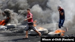 Demonstrators defy a curfew October 3, two days after nationwide anti-government protests turned violent in Baghdad last week.