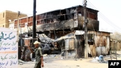 یو سوډانی سرتېری له پلازمېنې خرطوم سره نېږدې په جګړه کې سوځېدلې ودانۍ ته څېرمه تېرېږي - د ۲۰۲۵ د مې ۲۲مې انځور.