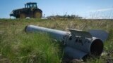 A fragment of a Russian missile is seen in as a farmer works on his field in Izyum, Kharkiv region, Ukraine, on April 20.
