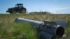 Трактор минава край фрагмент от руска ракета в Изюм, Харковска област, 20 април 2024 г.