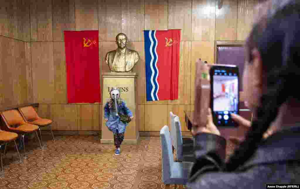 A woman takes a photo of her daughter in front of a bust of Lenin (whose name is spelled in the Latvian style: Lenins). Today the bunker is open for tourists to explore, though photography is forbidden in some rooms.