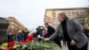 Foreign diplomats, including the U.S. Ambassador to Russia Lynne Tracy (right foreground), lay flowers at a monument to victims of political repressions in front of the former KGB headquarters in Moscow on October 30. A pro-Kremlin activist holding a flag with a portrait of Russian President Vladimir Putin stages a picket nearby. 