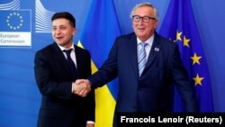 Ukrainian President Volodymyr Zelenskiy poses with European Commission President Jean-Claude Juncker at the EU Commission headquarters in Brussels on June 4.