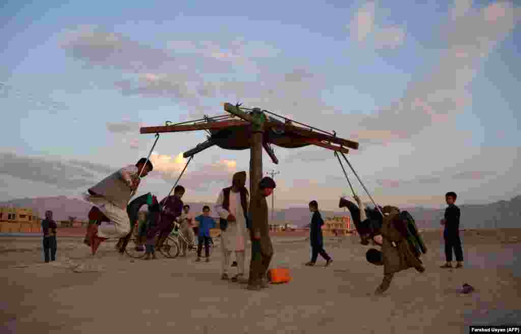 &nbsp;Afghan youths play on a swing at sunset on the outskirts of Mazar-e Sharif. (AFP/Farshad Usyan)