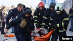 Спасатели несут получившего ранения при ударе России по вокзалу в Днепре. 29 октября 2026 года