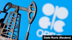 A 3D printed oil pump jack is seen in front of displayed Opec logo - generric