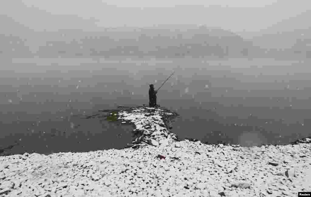A man fishes during a heavy snowfall on the banks of the Yenisei River outside Krasnoyarsk, Russia. (Reuters/Ilya Naymushin)