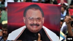 Supporters of Altaf Hussain, the leader of the Mutahida Qaumi Movement (MQM) political party hold his portraits as they gather in June 2014.