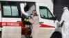 Medical workers wearing protective clothing take a suspected COVID-19 patient into quarantine. One Russian NGO says it's been contacted by many people in quarantine who feel abandoned without information.