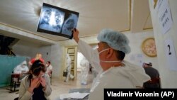 A medical specialist checks a woman's chest X-ray inside a restaurant that was converted into a clinic in Bishkek in July to battle the coronavirus.