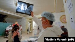 Медик проверяет рентген легких пациента в одном из временных стационаров в Бишкеке. Июль 2020 года.