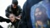 A Shi'ite Muslim has his head shaved alongside a picture of Imam Hussein on the eve of Ashura.
