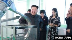 Лидер КНДР Ким Чен Ын посещает фабрику косметики в Пхеньяне вместе с женой (вторая свправа). 29 октября 2017 года.
