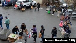 Люди стоять у черзі, щоб отримати їжу й інші товари в Евереті, Массачусетс, США, 20 березня 2020 року