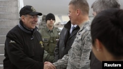 U.S. Defense Secretary Leon Panetta (left) is greeted by a serviceman as he arrives at the Manas Transit Center on March 13.