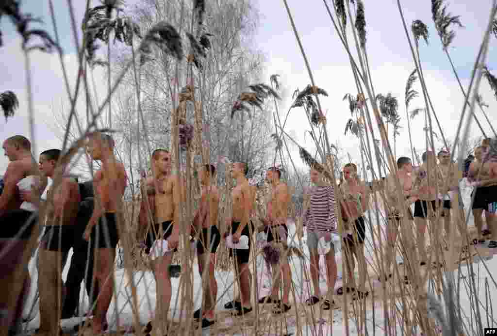 Belarusian soldiers line up to dip into the icy waters of a lake during the celebration of the Orthodox Epiphany holiday in the village of Zadomlya, some 40 kilometers east of Minsk on January 19. (AFP/Sergei Gapon)