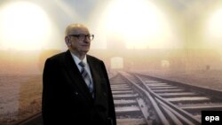 Німеччина. Колишній ув'язнений концентабору «Освенцім» (Auschwitz) Владислав Бартошевський навпроти картини концентраційного табору, Берлін, 16 лютого 2009 р.