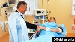 Tatarstan President Rustam Minnikhanov (left) visits Mufti Ildus Faizov in hospital after the cleric's car was rocked by powerful bomb blasts on July 19. 