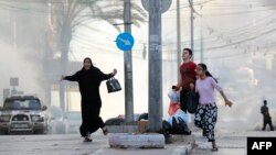 Civili palestinieni fug să se adăpostească în timpul unui atac aerian israelian în apropierea spitalului Al-Shifa din orașul Gaza, pe 1 noiembrie 2023.