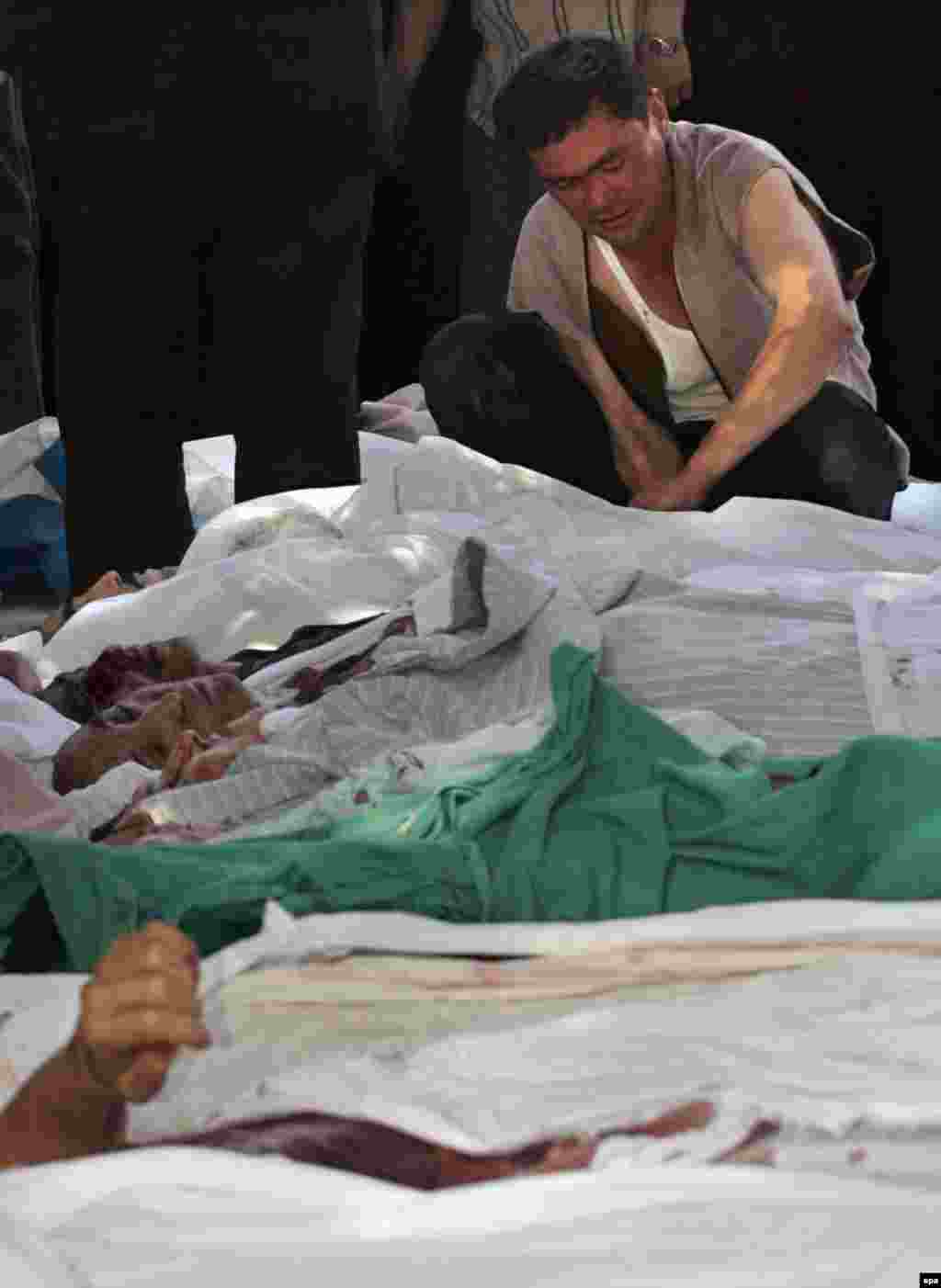 A man tries to identify a relative among the bodies - Early accounts by eyewitnesses and from local rights groups suggested that as many as 1,000 people had died.