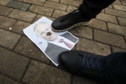 Портрет Путіна під ногами демонстрантів у Мінську