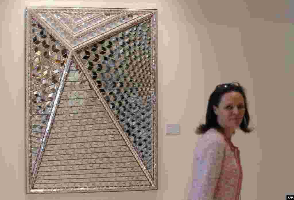 A visitor passes a painting titled by "Zahra's Image by Iranian artits Monir Farmanfarmaian during an exhibition at Christie's Auction house in Dubai on March 15, 2015 AFP PHOTO / KARIM SAHIB 
