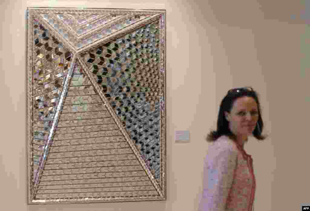 A visitor passes a painting titled by "Zahra's Image by Iranian artits Monir Farmanfarmaian during an exhibition at Christie's Auction house in Dubai on March 15, 2015 AFP PHOTO / KARIM SAHIB