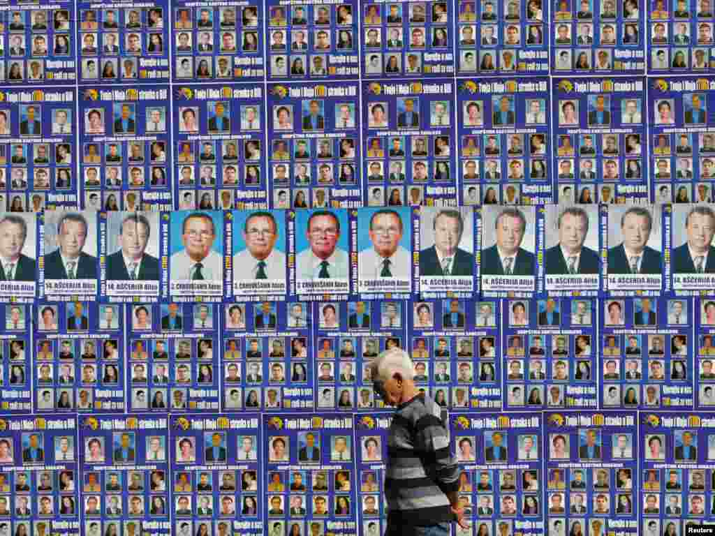 A man walks past a wall in central Sarajevo decorated with campaign posters ahead of Bosnia's October 3 parliamentary and presidential elections. Photo by Danilo Krstanovic for Reuters