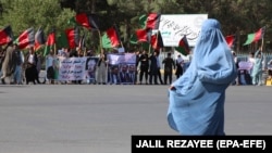 انځور له ارشیف څخه ـ د حزب وحدت اسلامي، جمعیت اسلامي او جنبش ګوندونو پلویان د ۲۰۱۸ کال د جولای په ۱۲مه په هرات کې د یوه لاریون پر مهال شعارونه ورکوي. 
