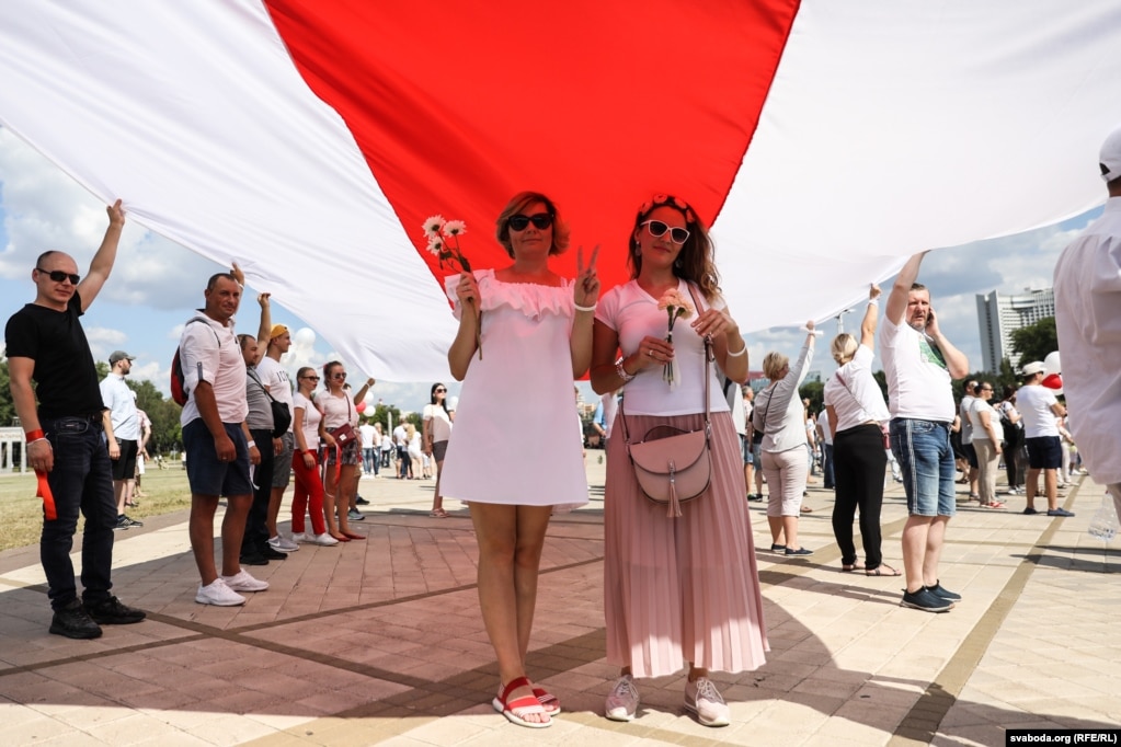 Die Leute trugen zwei riesige weiß-rot-weiße Flaggen ...