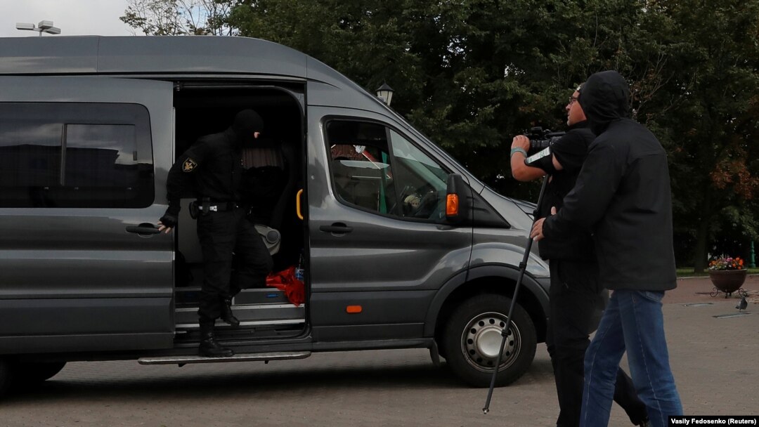 Polițiștii care au reținut un jurnalist care era în misiune sunt fotografiați de un fotograf Reuters cu puțin timp înainte de reținerea sa