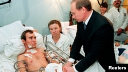 Премьер-министр России Владимир Путин с раненым в Чечне российским солдатом в военном госпитале под Москвой. 28 декабря 1999 года