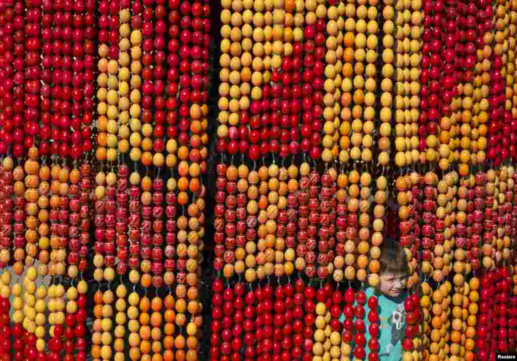 A boy plays with an installation made of painted wooden eggs, attributes of Orthodox Easter, in central Kyiv. Orthodox believers will celebrate Easter on May 5. (Reuters/Gleb Garanich)