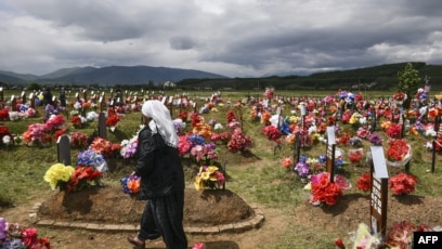 Në grua shqiptare ecën mes varreve të viktimave të masakrës së Mejës. Foto nga arkivi.
