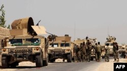 Afghan security personnel preparing to battle Taliban militants close to the city of Lashkar Gah.