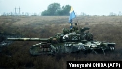 Український прапор над покинутим російським танком біля села Долина на Донеччині, 10 жовтня 2022 року
